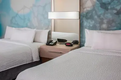 a hotel room with two beds and a mirror at Courtyard by Marriott Orlando Lake Buena Vista in the Marriott Village in Orlando