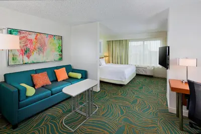 a hotel room with a couch and a bed at SpringHill Suites by Marriott Orlando Lake Buena Vista in Marriott Village in Orlando