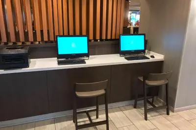 two computers sitting on a counter with chairs at SpringHill Suites by Marriott Orlando Lake Buena Vista in Marriott Village in Orlando