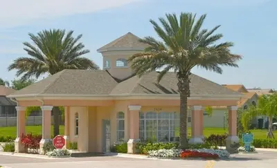a palm tree in front of a building with a stop sign at Sun Palm Disney Villa in Kissimmee