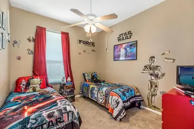a bedroom with two beds and a ceiling fan at Sun Palm Disney Villa in Kissimmee