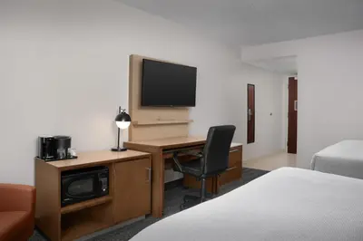 a hotel room with a desk and a television at Courtyard by Marriott Orlando East/UCF Area in Orlando