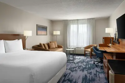 a hotel room with a large bed and a desk at Fairfield Inn Orlando Airport in Orlando