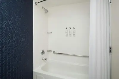 a bathroom with a white tub and a shower curtain at Fairfield Inn Orlando Airport in Orlando