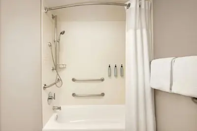 a bathroom with a shower and a tub and a sink at Residence Inn by Marriott Orlando East/UCF Area in Orlando