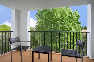 two chairs and a table on a balcony with a tree at Courtyard Orlando Altamonte Springs Maitland in Orlando