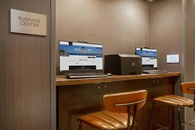 a desk with three monitors and a computer on it at Courtyard Orlando Altamonte Springs Maitland in Orlando