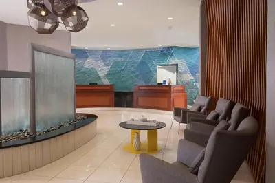 a waiting room with a large fish tank and chairs at SpringHill Suites Orlando Airport in Orlando