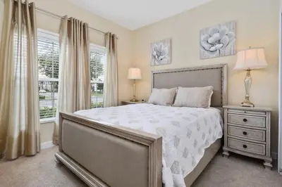 a bedroom with a large bed and two windows at Five Bedrooms Home with Pool 4851 in Kissimmee