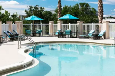 a swimming pool with chairs and umbrellas at Residence Inn by Marriott Near Universal Orlando in Orlando