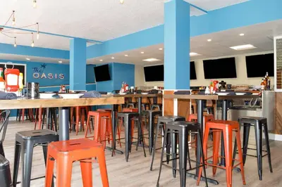a bar with stools in a restaurant with blue walls at Radisson Hotel Orlando Lake Buena Vista South in Kissimmee