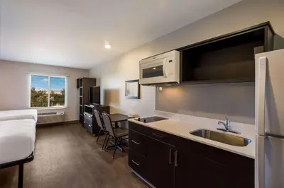 a small kitchen with a sink and a microwave at WoodSpring Suites Orlando West - Clermont in Clermont