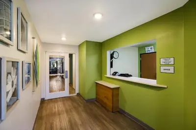 a hallway with green walls and a vanity and a mirror at WoodSpring Suites Orlando West - Clermont in Clermont