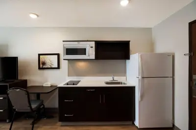 a kitchen with a white refrigerator and a microwave at WoodSpring Suites Orlando West - Clermont in Clermont