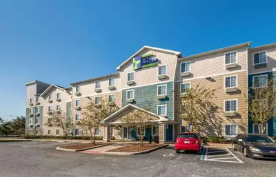 a hotel with a car parked in a parking lot at Extended Stay America Select Suites - Orlando - East in Orlando