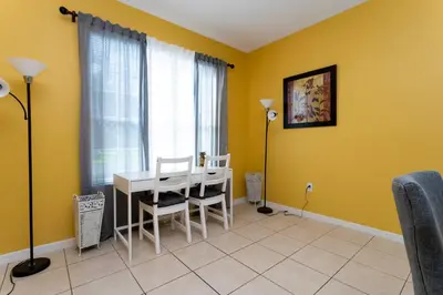 a dining room with yellow walls and a table and chairs at 7 Bedroom Mansion Near Disney in Kissimmee
