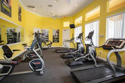 a gym with several treadmills and exercise bikes at 7 Bedroom Mansion Near Disney in Kissimmee