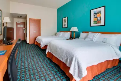 a hotel room with two beds and a flat screen tv at Fairfield Inn & Suites by Marriott Clermont in Clermont