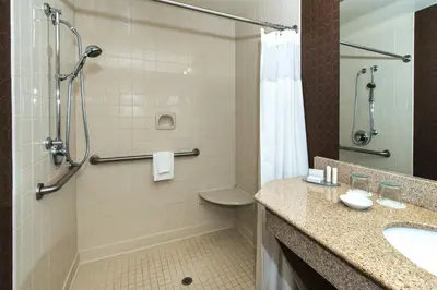 a bathroom with a shower and a sink and a toilet at SpringHill Suites by Marriott Orlando North-Sanford in Sanford