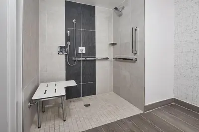 a shower with a bench in a bathroom at Orlando Marriott Lake Mary in Lake Mary