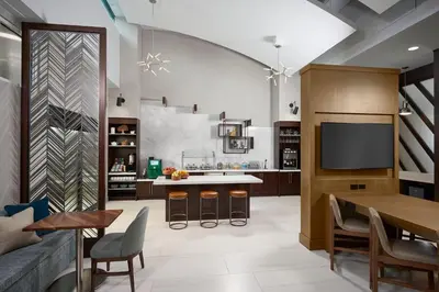 a living room with a kitchen with a table and a tv at Orlando Marriott Lake Mary in Lake Mary