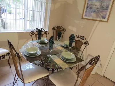 a dining room table and chairs with a glass table and chairs at 3 Bedroom Standard Davenport Home FL 33897 in Orlando