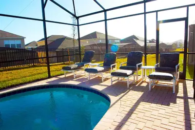 a group of chairs sitting next to a swimming pool at Windsor Hills Resort - Enchanted Crystal Castle in Orlando