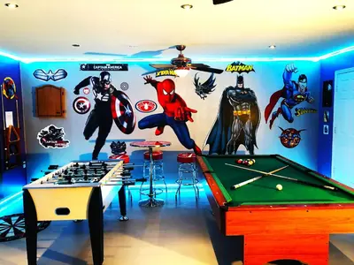 a room with a pool table and superheroes on the wall at Windsor Hills Resort - Enchanted Crystal Castle in Orlando