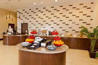a lobby with a counter with bowls of fruit on it at Plaza Suites On International Drive Near Universal Epic in Orlando
