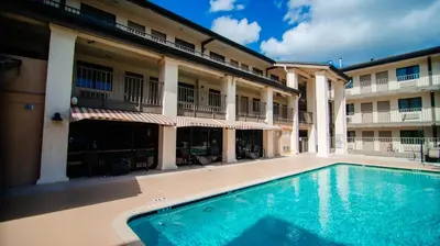 a swimming pool in front of a building at Quality Inn & Suites By the Parks in Orlando