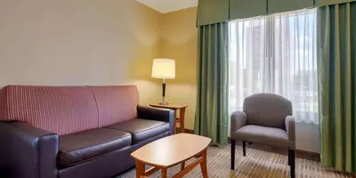 a living room with a couch and a chair at Extended Stay America Suites - Orlando - Orlando Theme Parks - Vineland Rd in Orlando