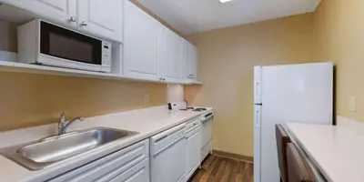 a kitchen with a sink and a white refrigerator at Extended Stay America Suites - Orlando - Orlando Theme Parks - Vineland Rd in Orlando