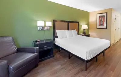 a bed and a couch in a room with a bed and a chair at Extended Stay America Suites - Orlando - Orlando Theme Parks - Vineland Rd in Orlando