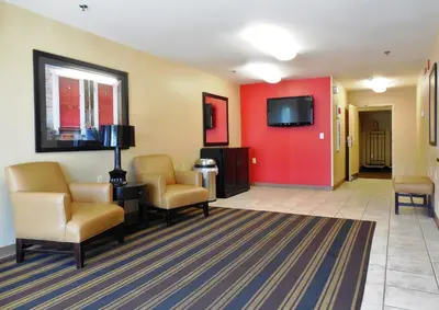 a waiting room with chairs and a flat screen tv at Extended Stay America Suites - Orlando - Orlando Theme Parks - Vineland Rd in Orlando