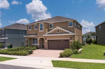 a house with a garage in a residential neighborhood at Wilmington Loop 6 Br Luxury Villa with Pool and Spa in Orlando