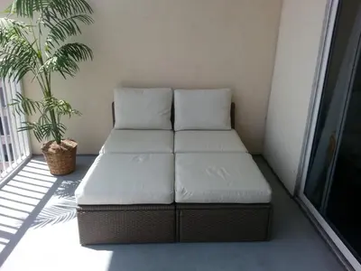 a bed sitting on a balcony with a plant at Penthouse Blue Heron Condo in Orlando