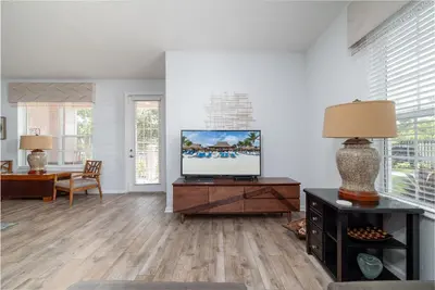 a living room with a television on a wooden table at La Vista Lakeview Condo in Orlando