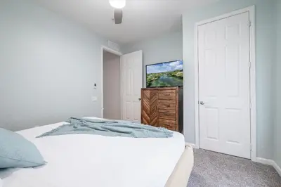 a bedroom with a white bed and a white door at La Vista Lakeview Condo in Orlando