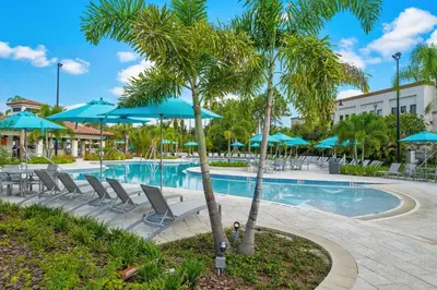 a pool at a resort with chairs and umbrellas at Miranda's Gem Condo in Orlando
