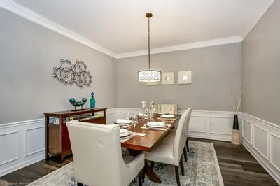 a dining room with a wooden table and white chairs at Miranda's Gem Condo in Orlando