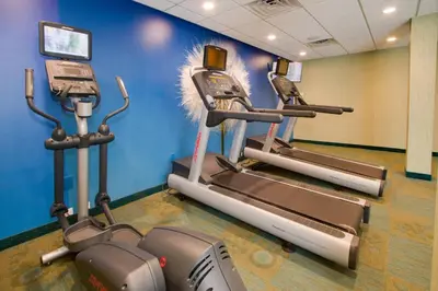 a gym with three tread machines in a room at SpringHill Suites by Marriott Orlando Lake Buena Vista South in Kissimmee