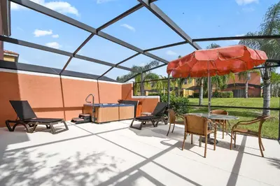 a patio with a table and chairs and an umbrella at Three Bedrooms Townhome 3012 in Kissimmee