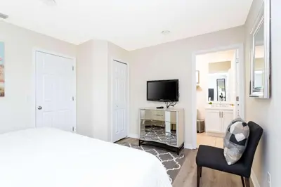 a bedroom with a bed and a tv and a chair at Three Bedrooms Townhome 3012 in Kissimmee
