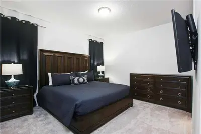 a bedroom with a bed and a flat screen tv at DREAM HOUSE, ECOLAB Sanitzed NEAR DISNEY, POOL FENCE in Orlando