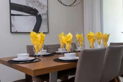 a dining room table with yellow vases and chairs at Four Bedrooms TownHome 4861 in Kissimmee