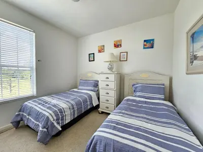 two twin beds in a room with a window at Windsor Palm Condo #213421 in Kissimmee