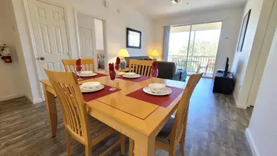 a dining room with a wooden table and chairs at Windsor Palm Condo #213421 in Kissimmee