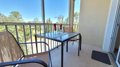a balcony with a glass table and chairs on it at Windsor Palm Condo #213421 in Kissimmee