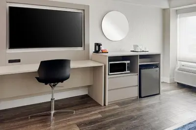 a room with a tv and a chair and a microwave at Wyndham I-Drive Avanti Resort & Conference Center in Orlando