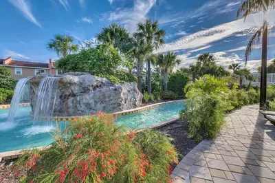 a swimming pool with a waterfall in a yard at Family Vacation Villa, Water Park, Endless Amenities in Kissimmee